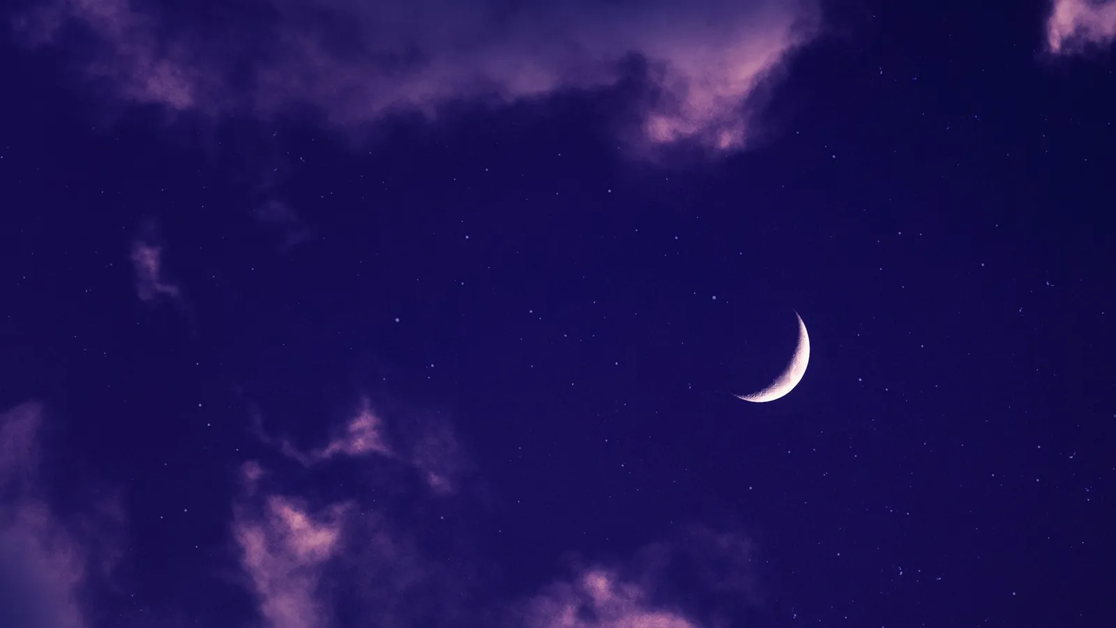 Croissant de lune dans un ciel violet et nuageux